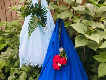 light blue and dark blueupcycled t-shirt tote bags hanging from a tree