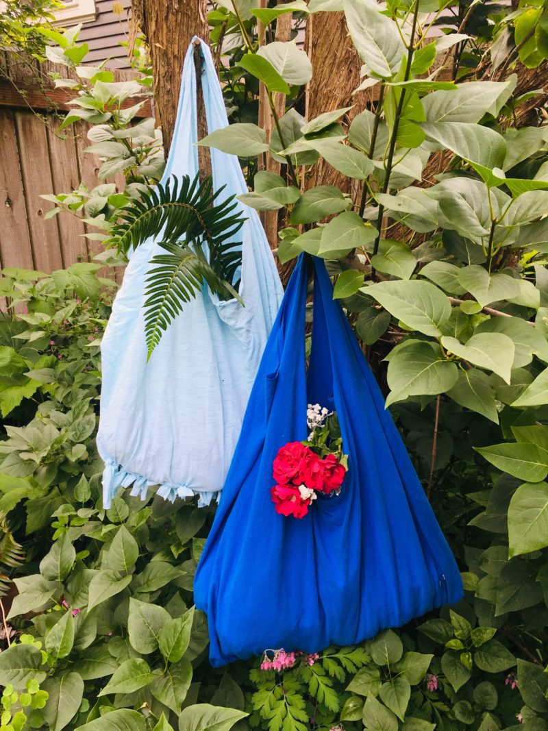 light blue and dark blueupcycled t-shirt  tote bags hanging from a tree