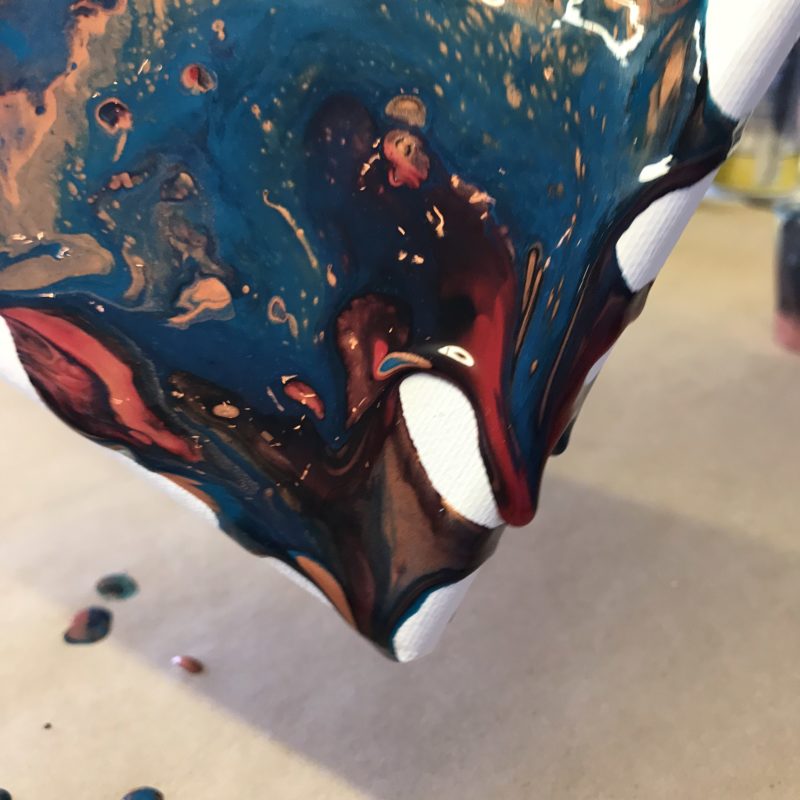 acrylic paint pouring on the corner of a canvas covering edges