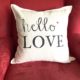 Hello Love text painted on a white pillow sitting on a red chair