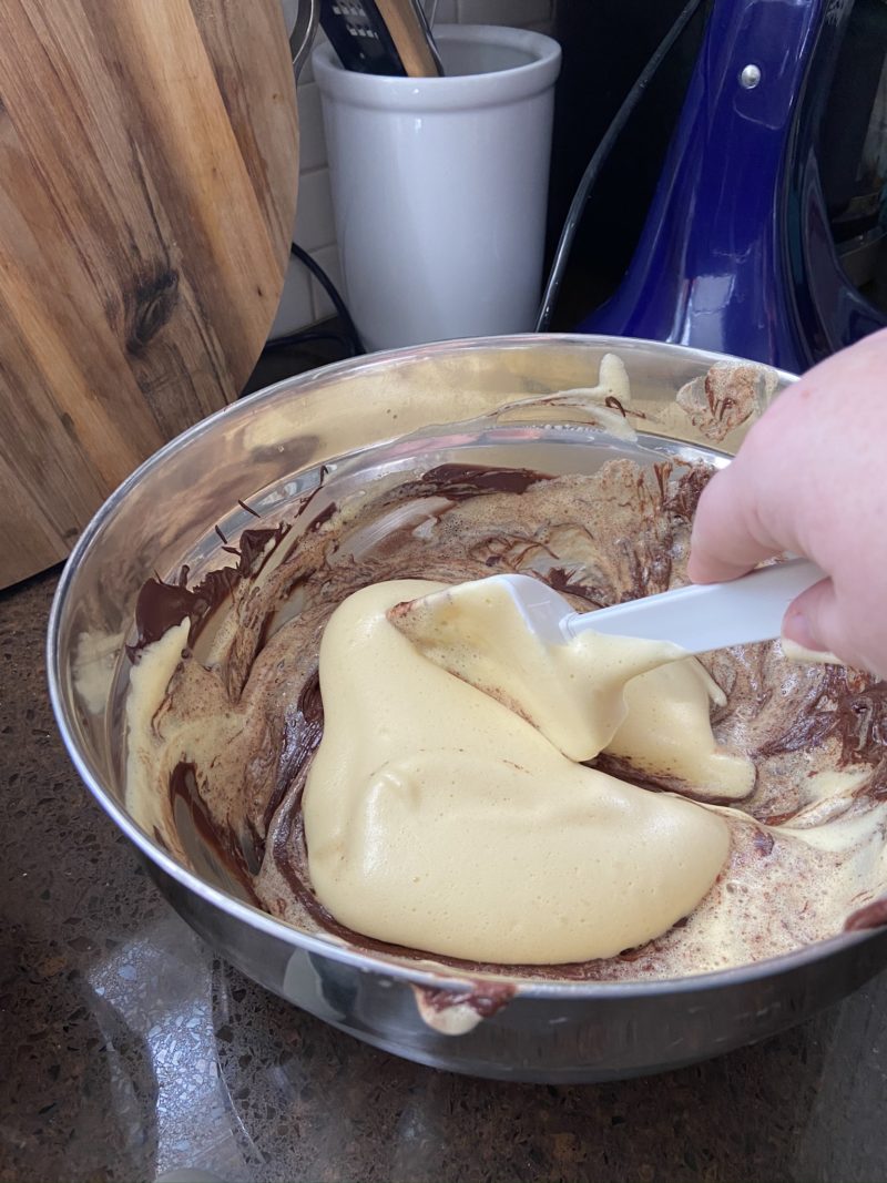 folding chocolate into whipped eggs for a chocolate cake