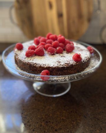 Chocolate Cake on a plate with raspberries and whipped cream